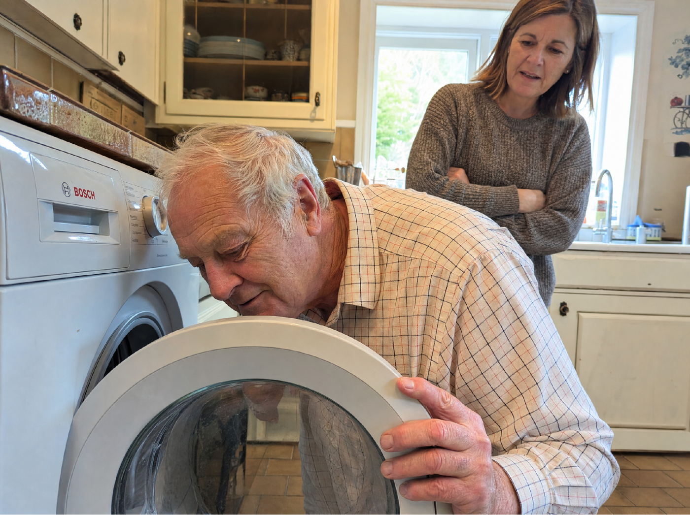 Grandpa and granddaughter looking at a washing machine